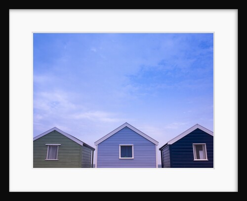 Beach huts in a row against sky by Assaf Frank